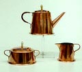 Driedelig koperen servies bestaande uit theepot suikerpot melkkannetje deksels voorzien van ivoren knoppen ontwerp Jan Eisenloeffel uitvoering Amstelhoek / Amsterdam ca.1900 