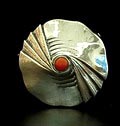 Zilveren geciseleerde Amsterdamse School broche met ronde cabuchon geslepen bloedkoraal ontwerp Fons Reggers uitvoering Gebr.Reggers Amsterdam 1923-1934 