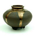 Ongeglazuurde Unicum vaas zg serre-stuk met brons-goud gelusterde druipglazuur decoratie in stervorm op losse aardewerk voet ontwerp uitvoering Pieter Groeneveldt Voorschoten 1979 