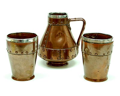 Stoneware Copper Ware jug with two beakers with simulated copper rivets all with sterling silver mounted rim design execution by Doulton Lambeth Silicon 1893 / England Copper Ware was introduced in the late 1800's by Doulton Lambeth Silicon reflecting the Arts and Crafts influence of the era 