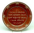 Aardewerk spreukenbord met geringeloorde decoratie en tekst Hij die als vriend hier binnen gaat komt nooit te vroeg maar steeds te laat ontwerp C.J.van der Hoef uitvoering VH Amstelhoek 1904-'10 