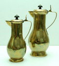 Twee geelkoperen mokka-kannen aangezette tuit en handvat gedraaide houten knop ontwerp toegeschreven aan Jan Eisenloeffel 1899-1904 zie lit.verm uitvoering Amstelhoek / Holland Hoogtes 23 18,5 cm 
