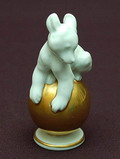 Wit geglazuurd beeldje van jonge beer op gouden bal ontwerp M.H.Fritz 1939 uitvoering Rosenthal / Selb Plössberg ca.1955 