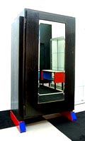  Mahonie hangkast met spiegeldeur zwart gelakte kast op rood blauw gelakte blokken ontwerp uitvoering Hildo Krop Herkomst Uitgevoerd door Hildo Krop ca.1930 oorspronkelijk voor eigen gebruik gemaakt en in 1963 geschonken aan de zoon van de kunstenaar Johan Krop 