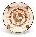 Aardewerk herinnerings- wandschotel met een sjabloondecor in bruin en groen met afbeelding van een vredesduif met de tekst D.K,SF.N.L en Vrede 31.8.1918 en op de rand A.N.D.B Algemene Nederlandse Duivensport Bond uitvoering de Distel / Amsterdam 
