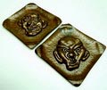 Twee roodkoperen wandplaquettes met masker ontwerp uitvoering F.Wolterman ca.1930 