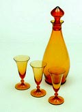 Amber glazen likeurkaraf Romanda met drie bijbehorende likeurglaasjes ontwerp A.D.Copier 1923 uitvoering Glasfabriek Leerdam 