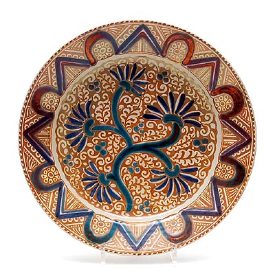 Earthenware wall-plate with painted geometrical rim-decoration floral decoration in the middle in goldyellow lustre green blue and brown painted by Cornelis Hartog executed by the Porceleyne Fles Delft / the Netherlands ca.1930 