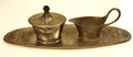 Tinnen blaadje met melkkannetje en suikerpot ontwerp Hugo Leven 1874-1956 uitvoering Kayserzinn / Duitsland 1900-1902 Maten Melk 14 x 9,2 cm Suiker 10,5 x 10,5 cm Blaadje 36,8 x 11,7 cm 